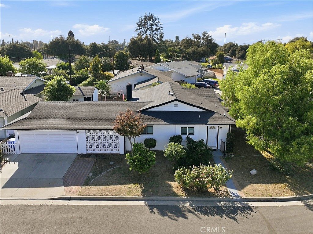 Aerial view of a single-story white house with a two-car garage and breeze-block front accent on a corner lot, 10762 Lynrose St, Temple City